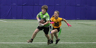 girl and boy playing flag football